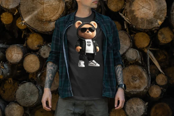 Hombre con camiseta negra que presenta un oso de peluche vestido con sudadera negra, gafas de sol, zapatillas blancas y camiseta blanca con logo de calavera, combinado con una camisa de cuadros abierta. Ideal para amantes del streetwear y moda urbana con detalles de hip hop.